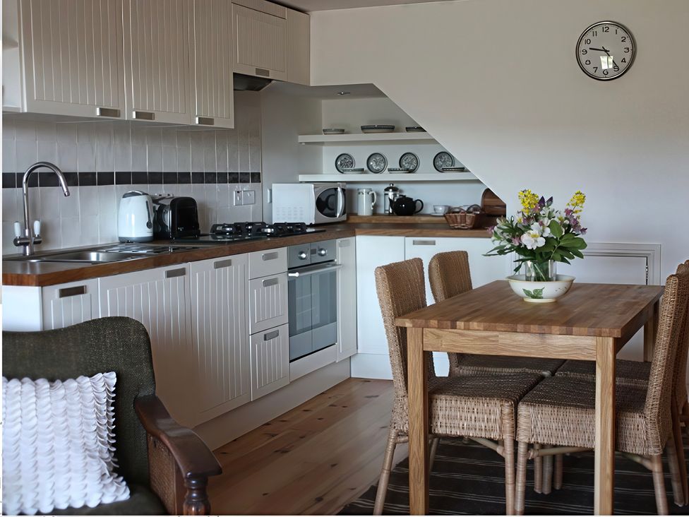 A kitchen with a dining table and chairs at Cottage 2