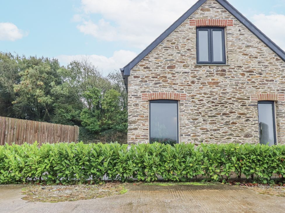 A house with windows and a hedge in front at Barn 2