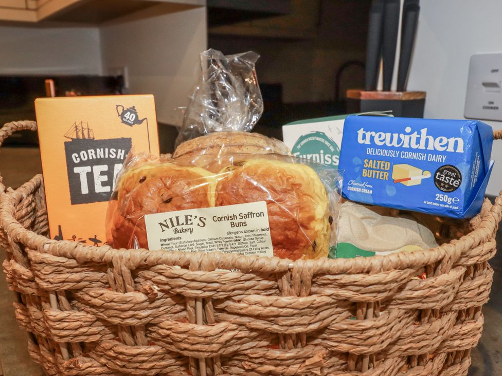 A wicker basket containing tea, buns and butter at Barn 2