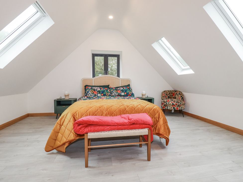 A bedroom with a bed and armchair at Barn 2