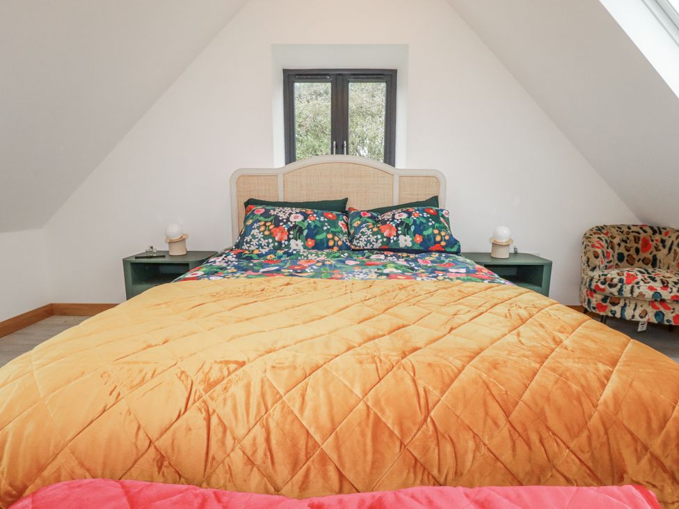 A bedroom with a bed and armchair at Barn 2