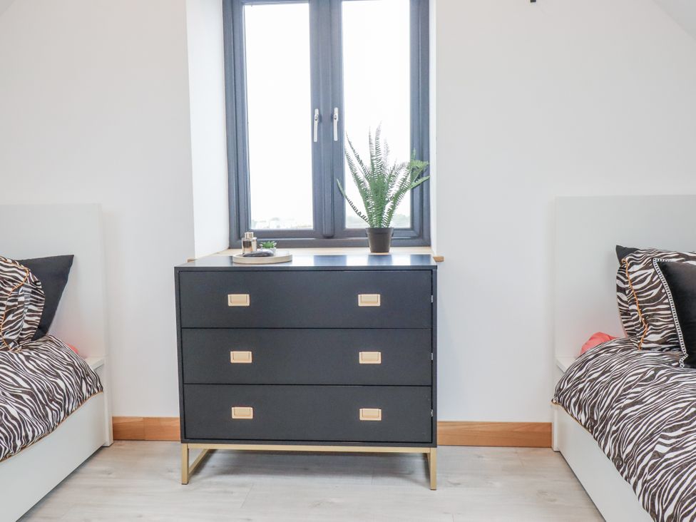 A bedroom with a dresser and beds at Barn 2