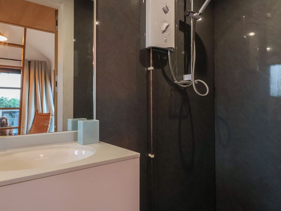 A bathroom with a shower and mirror at The Bothy