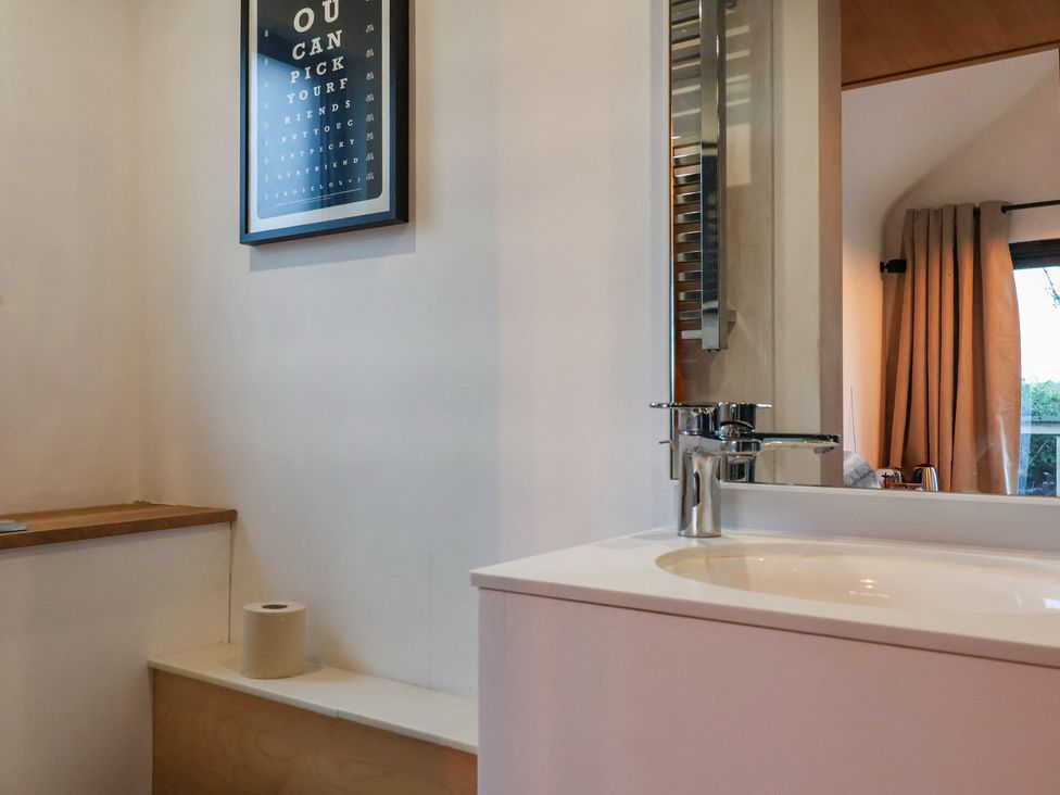 A bathroom with a sink and wall art at The Bothy