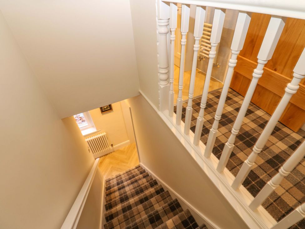 A staircase with a handrail leading to a hallway at Milford in Great Corby, Wetheral