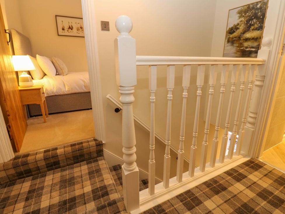 A hallway with a staircase and bedroom entrance at Milford, Great Corby, Wetheral