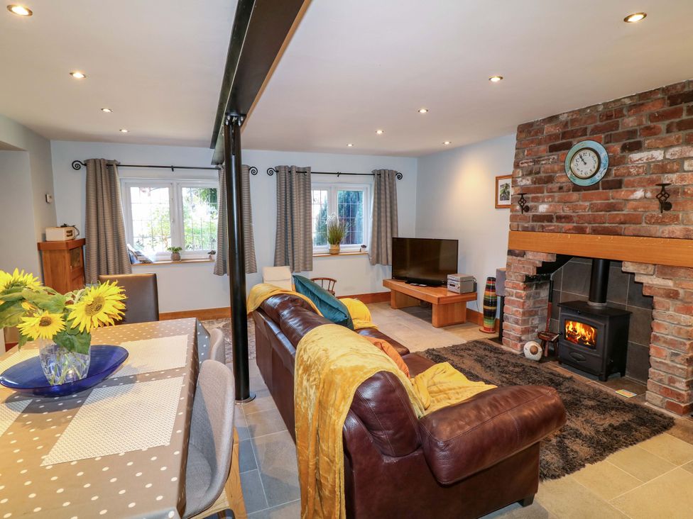 A living room with a sofa and fireplace at 6 Brook Court in Thulston near Derby