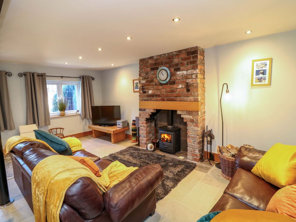A living room with a fireplace and television at 6 Brook Court Thulston near Derby