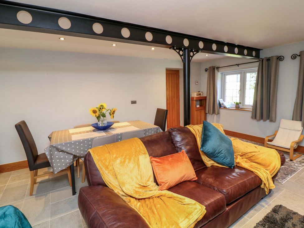 A living room with a dining table and sofa at 6 Brook Court in Thulston near Derby