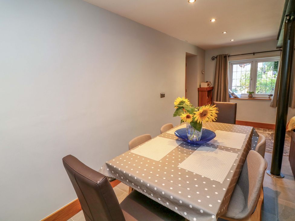 A dining room with a table and chairs featuring flowers at 6 Brook Court Thulston near Derby