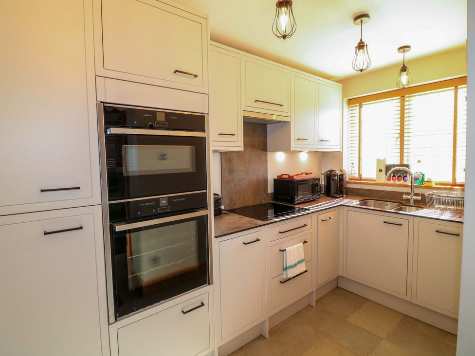 A kitchen with an oven and microwave along with a sink at 6 Brook Court Thulston near Derby