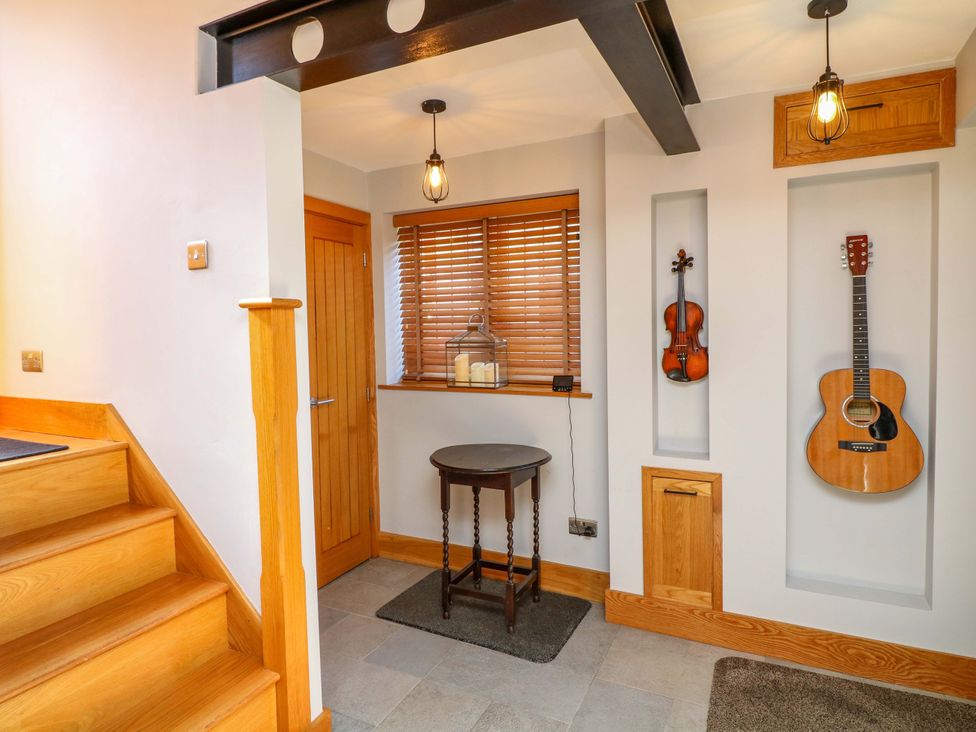 A hallway with a table and musical instruments at 6 Brook Court in Thulston near Derby