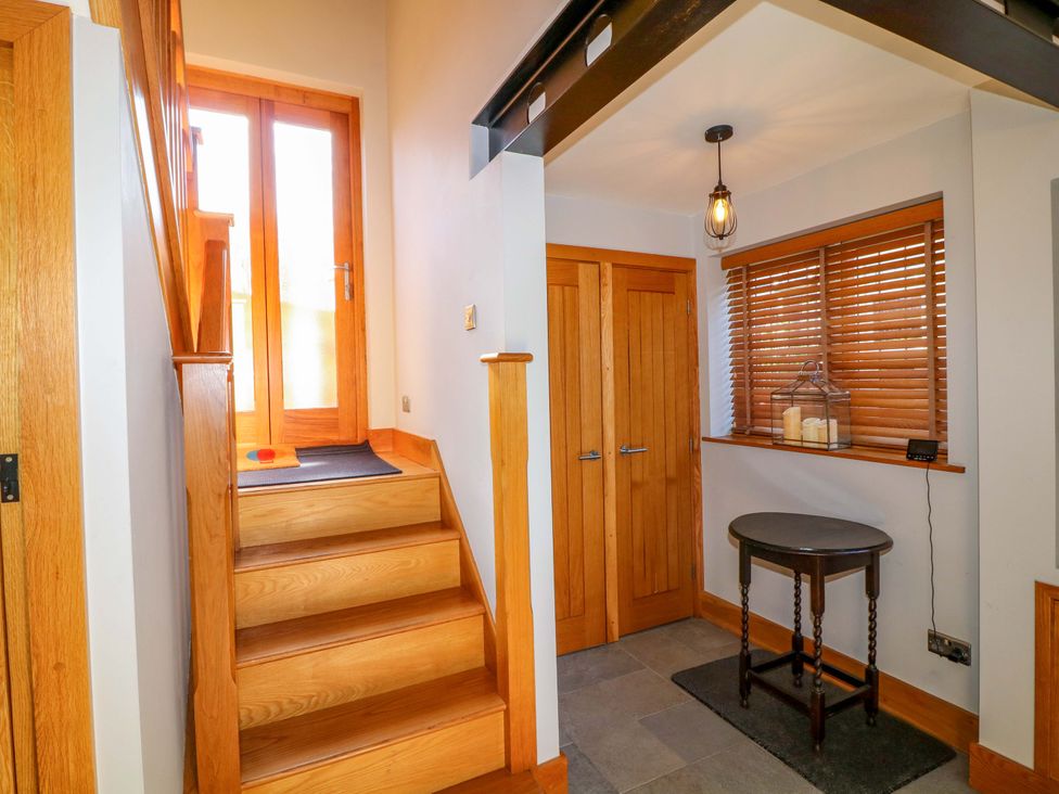 A hallway with stairs and a table at 6 Brook Court in Thulston near Derby