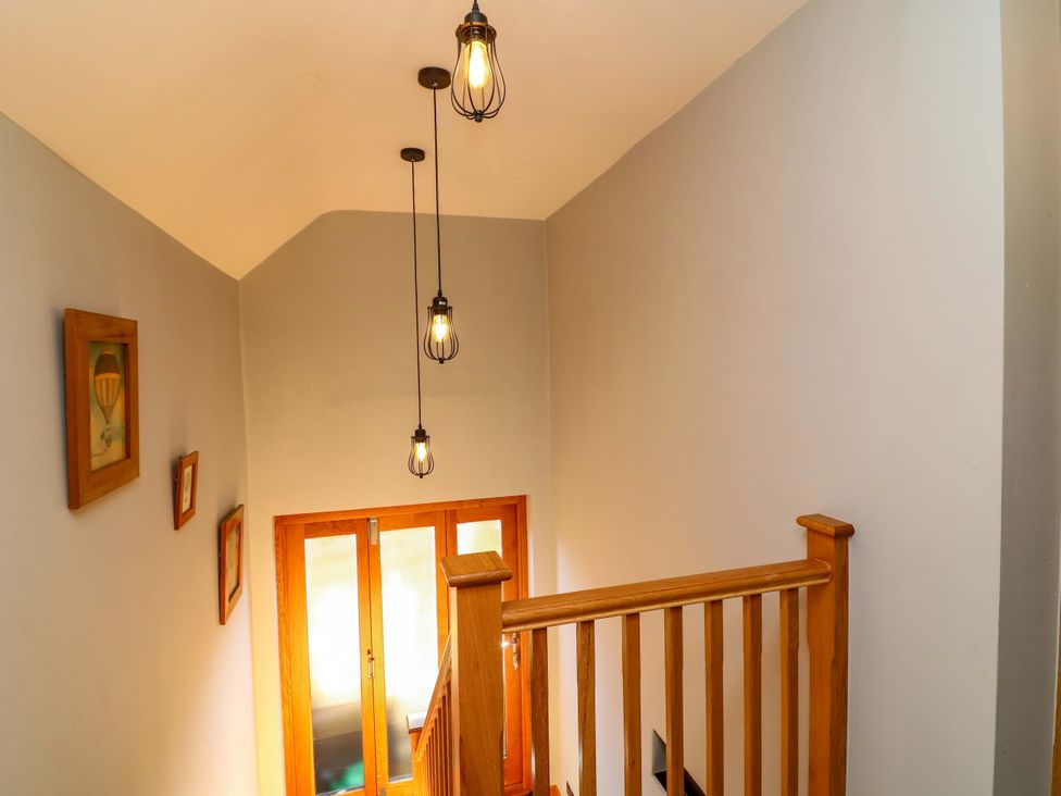 A stairwell with a railing and light fixtures at 6 Brook Court Thulston near Derby