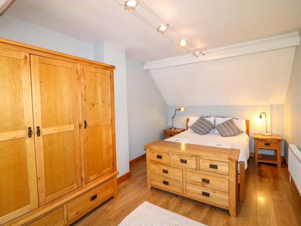 A bedroom with wooden furniture and a bed at 6 Brook Court in Thulston near Derby