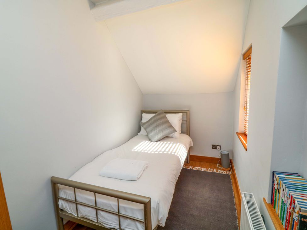 A bedroom with a single bed and a bookshelf at 6 Brook Court in Thulston near Derby