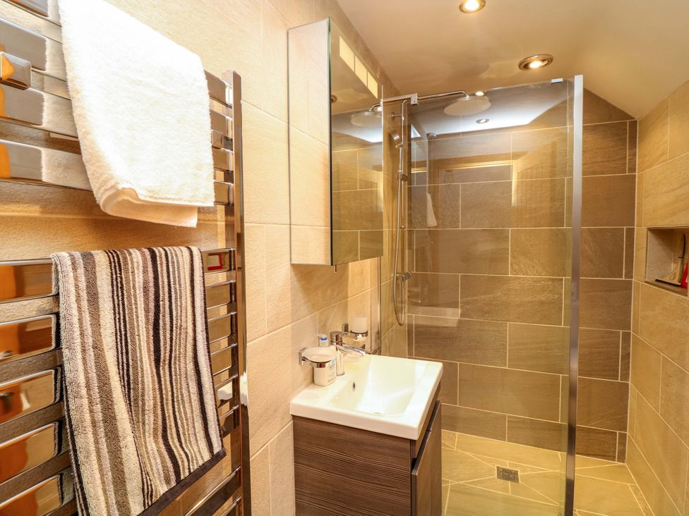 A bathroom with a shower, sink and towel radiator at 6 Brook Court Thulston near Derby