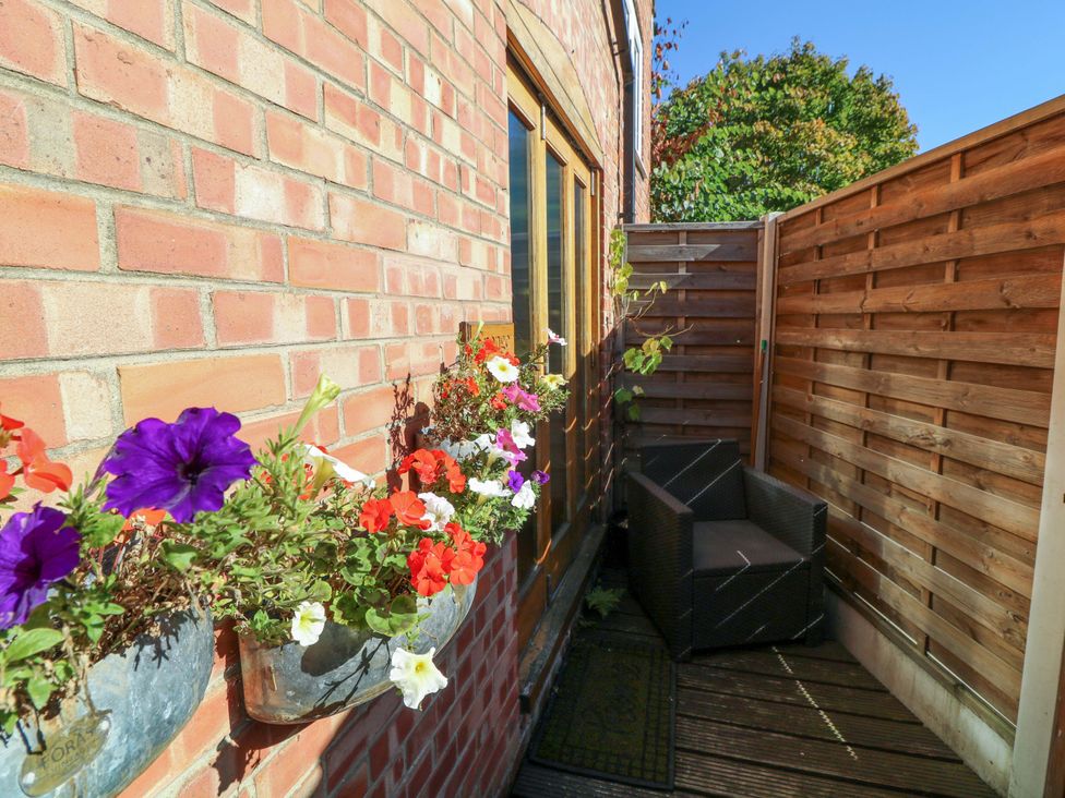 An outdoor area with flowers and a chair at 6 Brook Court Thulston near Derby