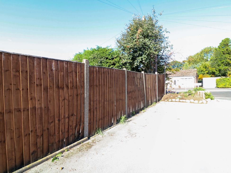 A wooden fence with a tree and building at 6 Brook Court in Thulston near Derby