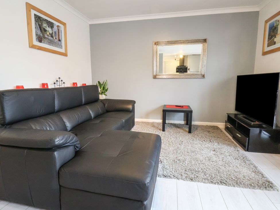 A living room with a sofa, coffee table and television at Flat 12 in Wallasey