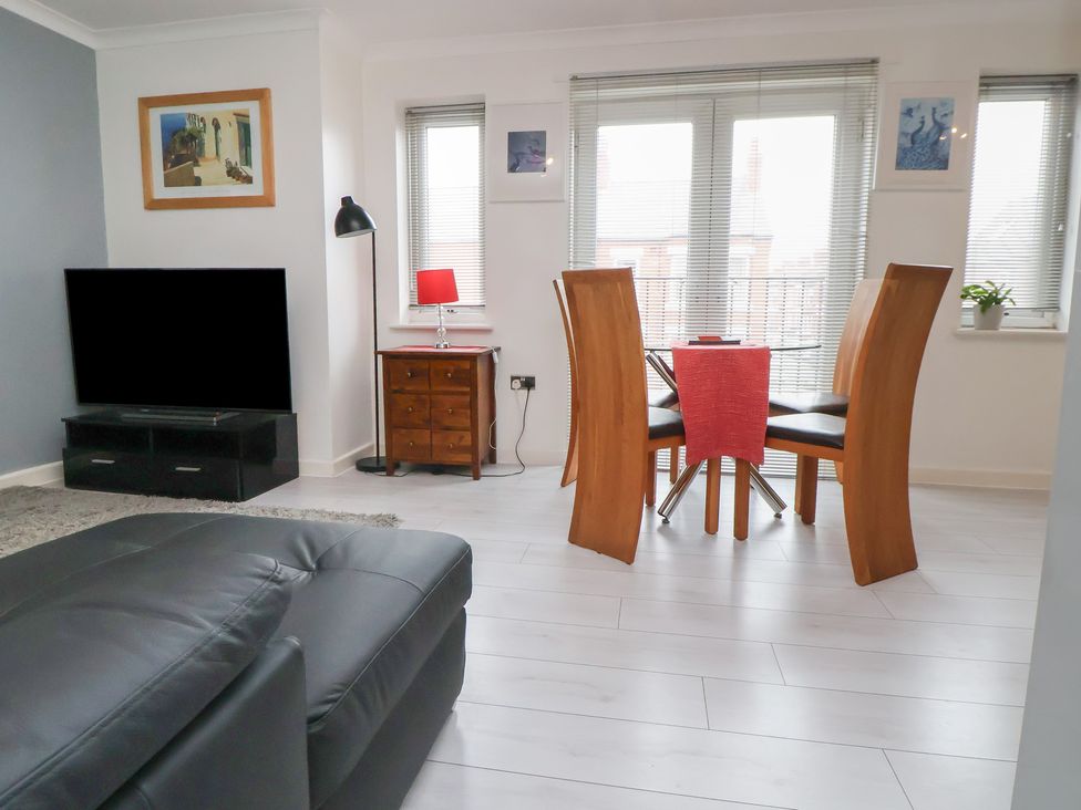 A living room with a tv and dining table at Flat 12 in Wallasey