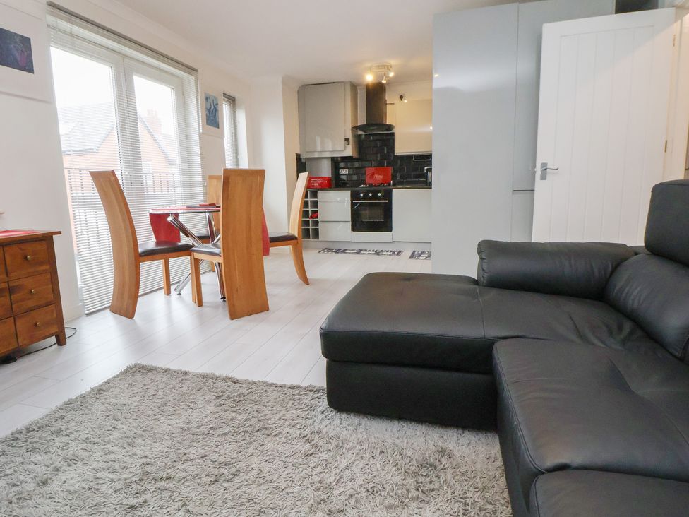 A living room with a sofa and dining area at Flat 12 in Wallasey
