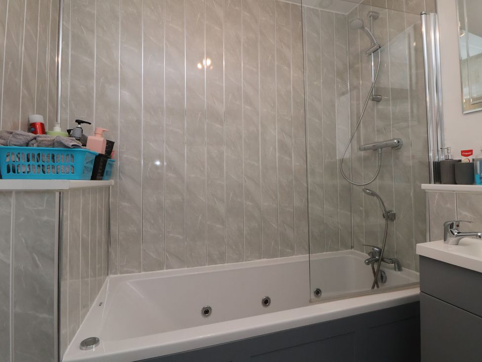A bathroom with a bathtub and a shower at Flat 12 in Wallasey