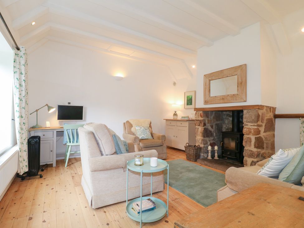 A living room with furnishings and a fireplace at Pigwig Cottage