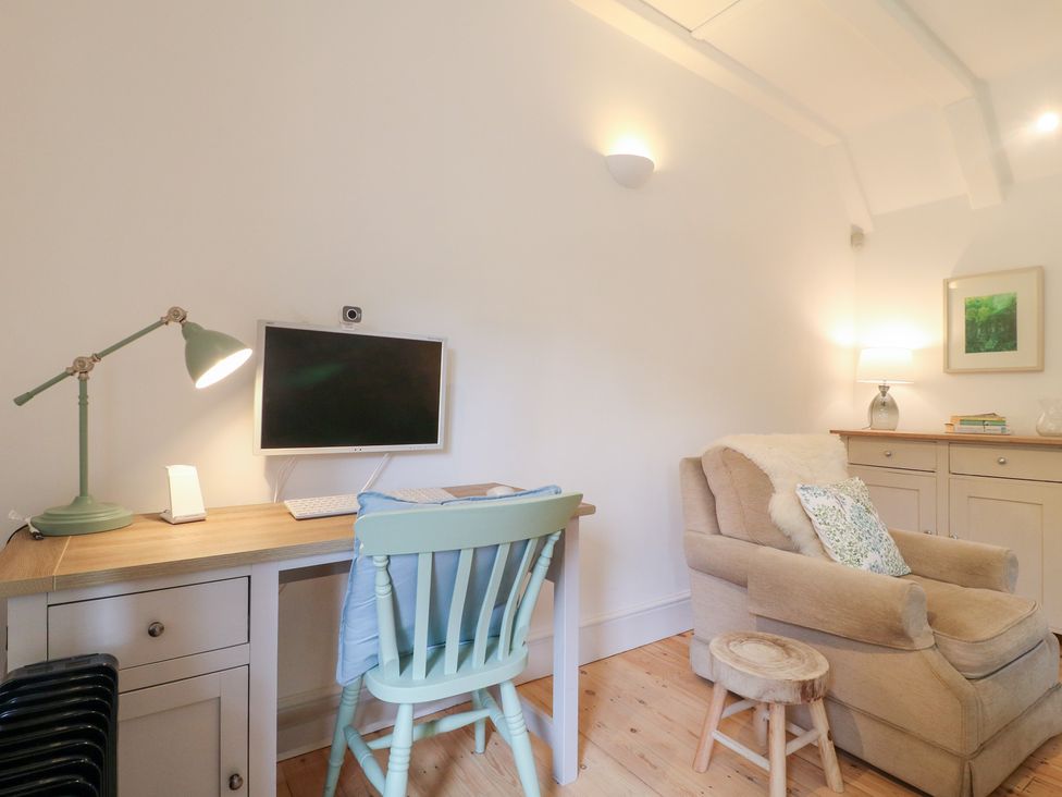 A home office with a desk and computer monitor at Pigwig Cottage 