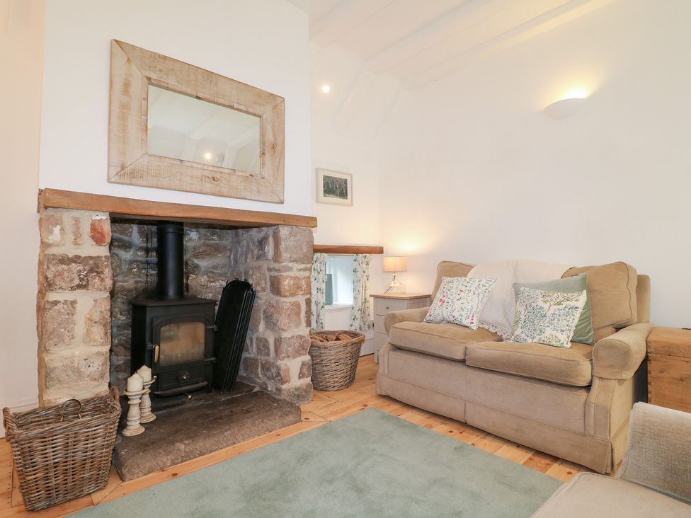 A living room with a fireplace and sofa at Pigwig Cottage