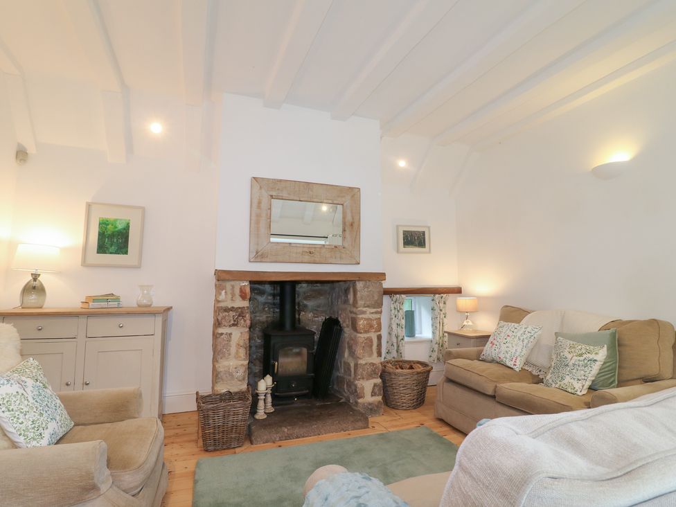 A living room with a fireplace and seating at Pigwig Cottage