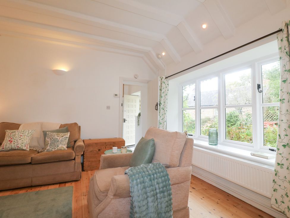 A living room with a sofa and armchair at Pigwig Cottage