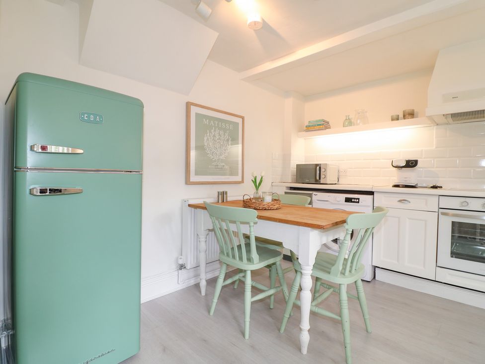 A kitchen with a table and chairs at Pigwig Cottage
