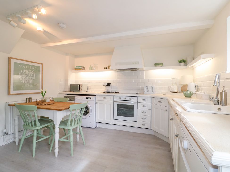 A kitchen with a table and chairs at Pigwig Cottage