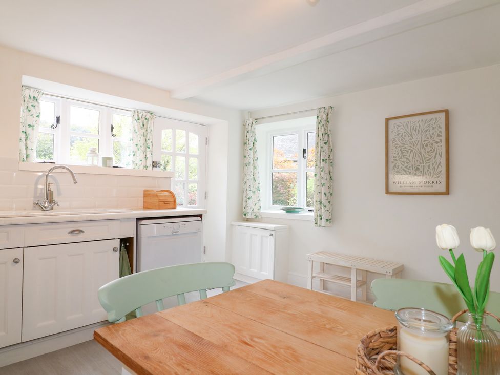 A kitchen with a table and chairs at Pigwig Cottage