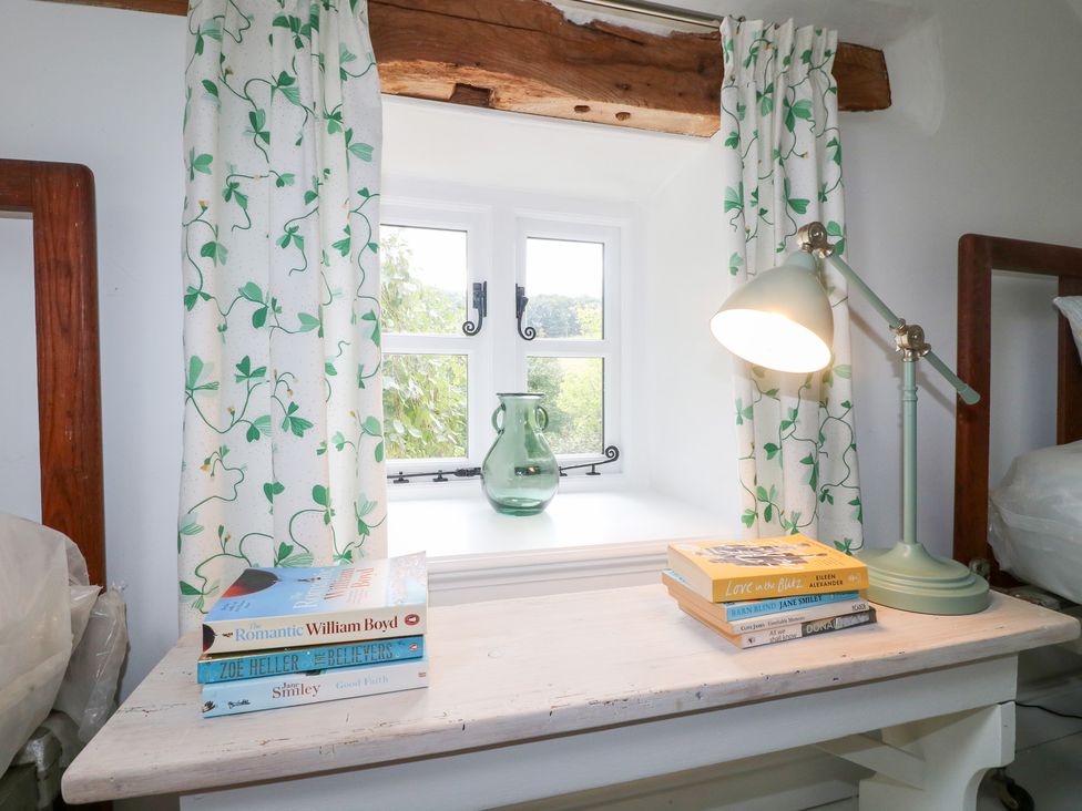 A window with curtains and a desk lamp at Pigwig Cottage