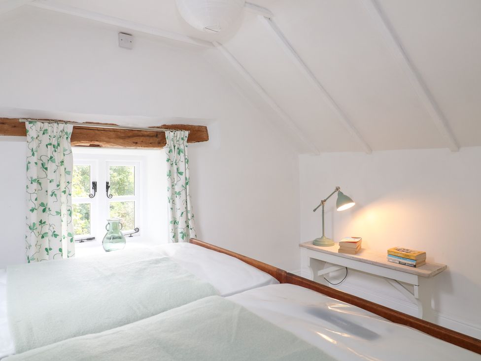A bedroom with a bed and a window at Pigwig Cottage