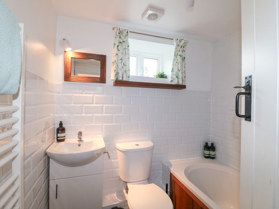 A bathroom with a sink, toilet, and bathtub at Pigwig Cottage