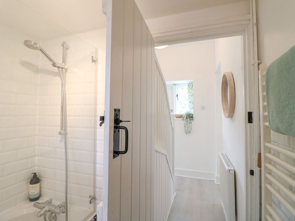 A bathroom with a shower and towel rack at Pigwig Cottage