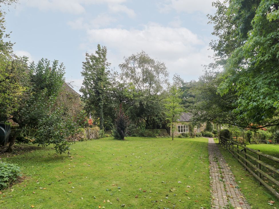 A garden with a pathway and trees at Pigwig Cottage