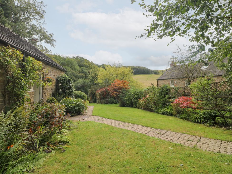 A garden with a pathway and cottage at Pigwig Cottage