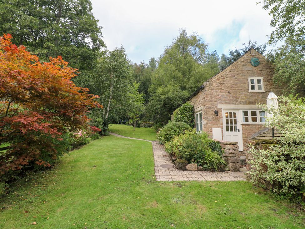 A cottage with a garden and pathway at Pigwig Cottage