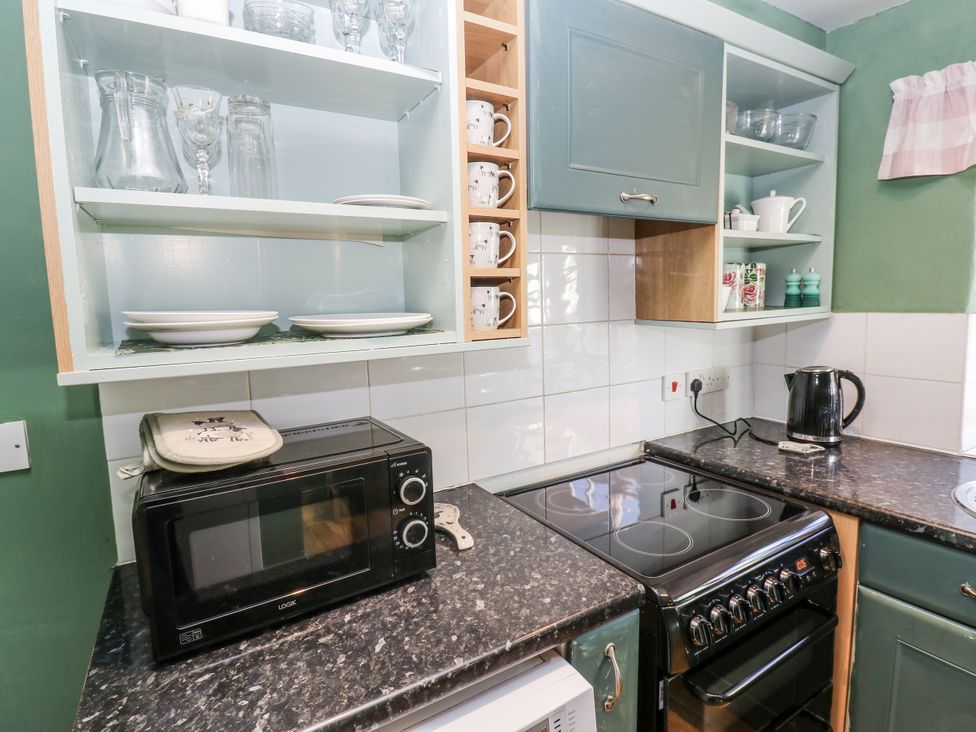 A kitchen with a microwave and an oven at Ewe Cottage in Ripon