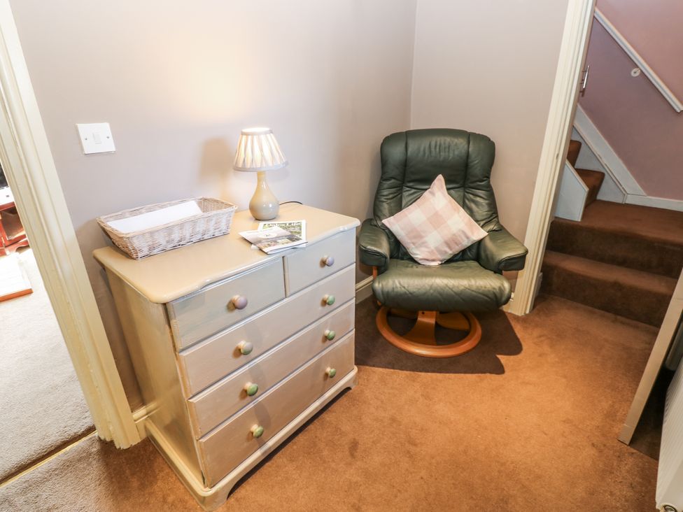A hallway with a chest of drawers and an armchair at Ewe Cottage in Ripon