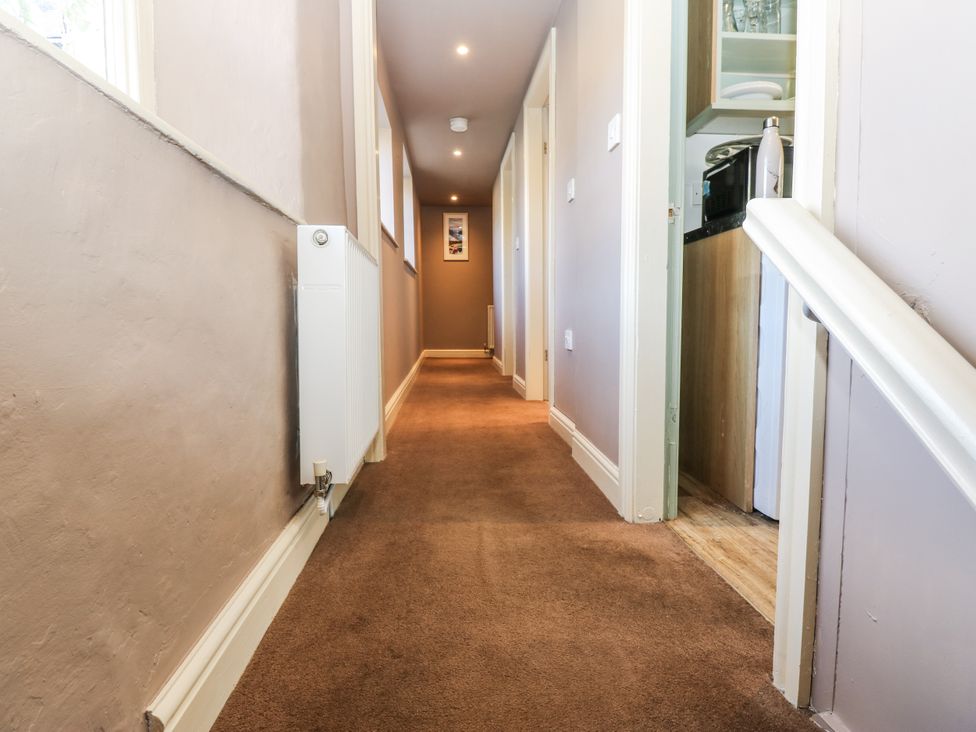 A hallway with a radiator and doorways at Ewe Cottage in Ripon