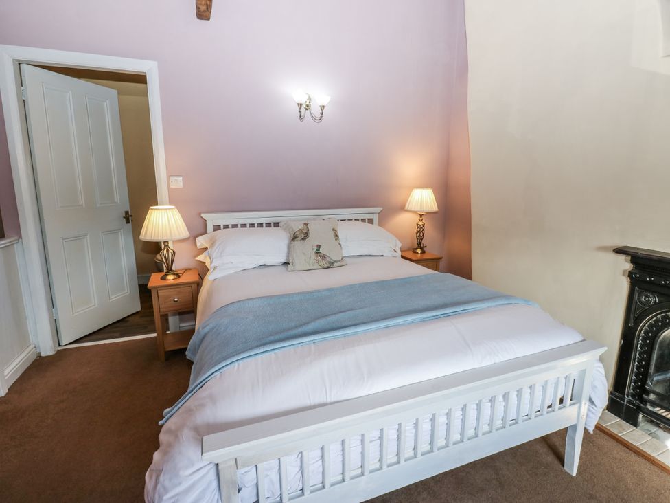 A bedroom with a bed and bedside table at Ewe Cottage in Ripon