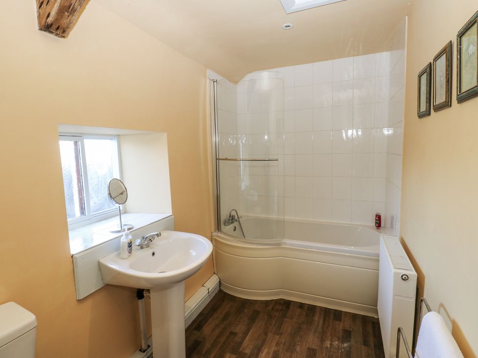 A bathroom with a bathtub and sink at Ewe Cottage in Ripon