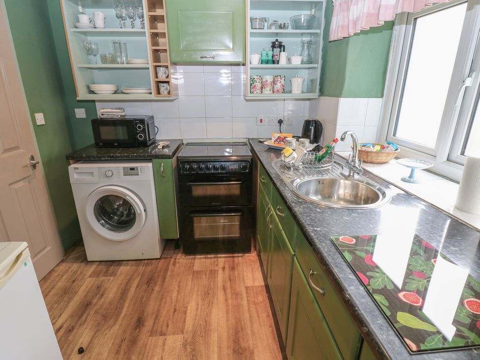 A kitchen with appliances and dishes at Ewe Cottage in Masham