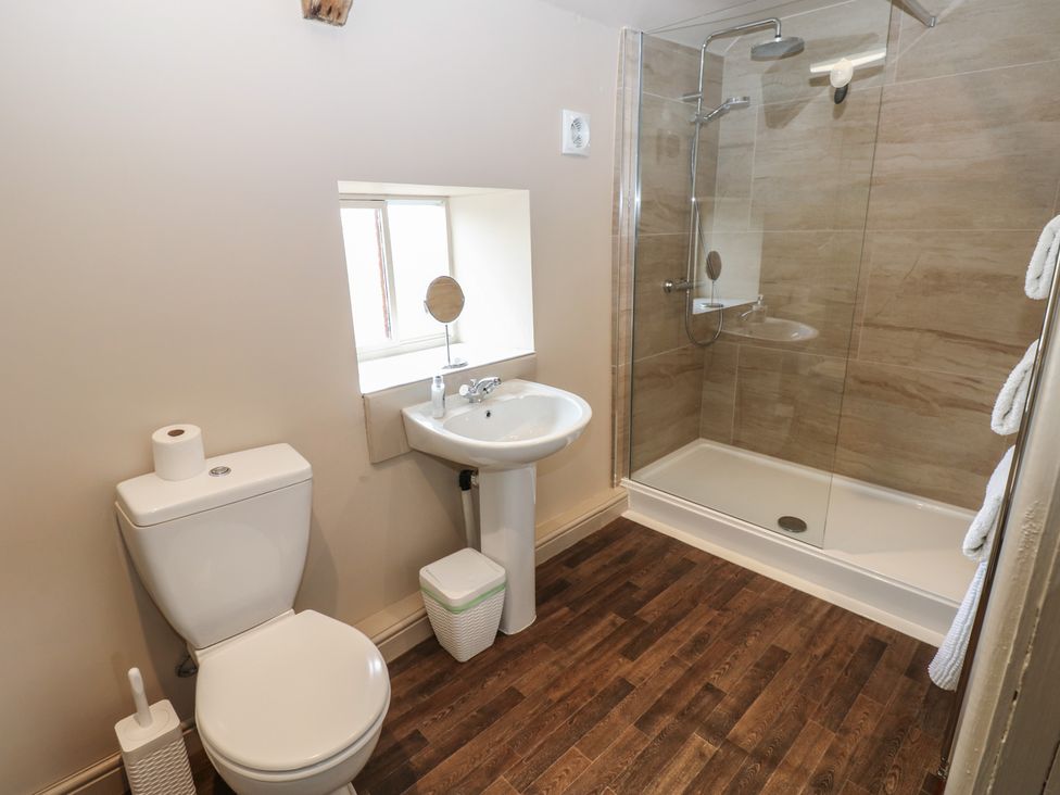 A bathroom with a toilet, sink, and shower at Ewe Cottage in Masham