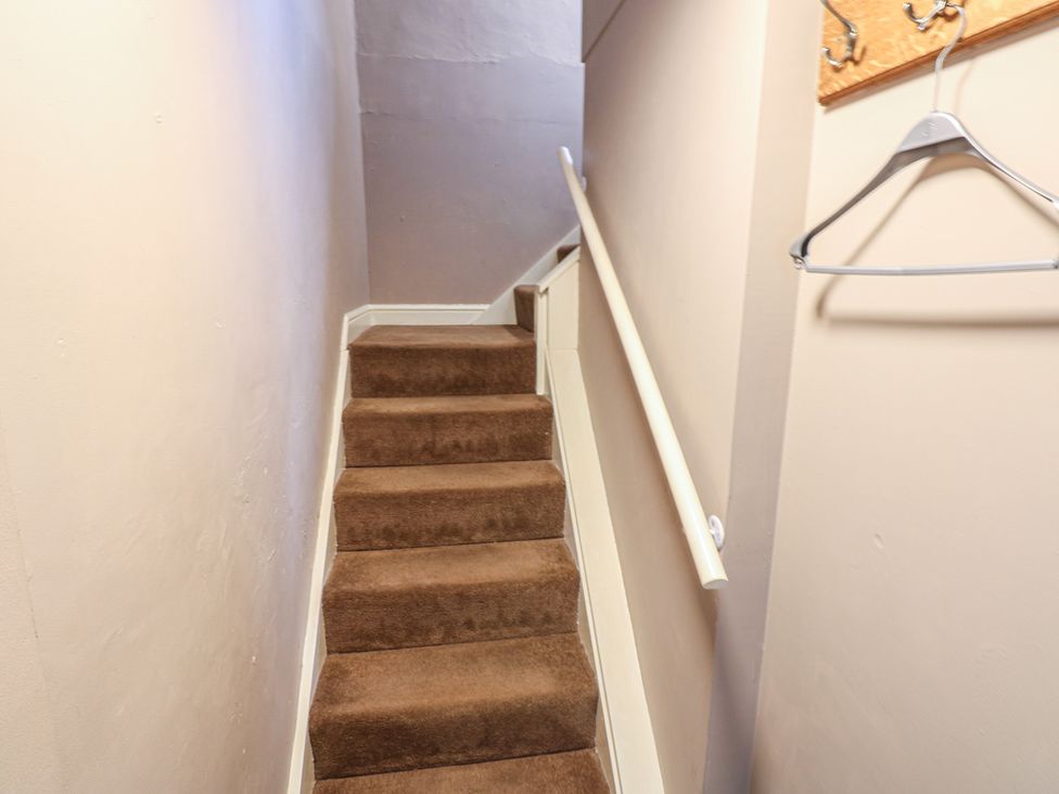 A staircase with carpet and handrail at Ewe Cottage in Masham